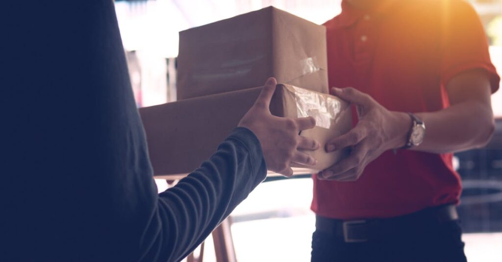 出張買取で箱詰めされたお酒を業者が回収している場面